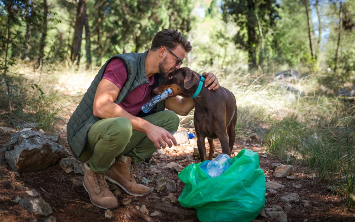 Homme avec son chien ramassant des déchets